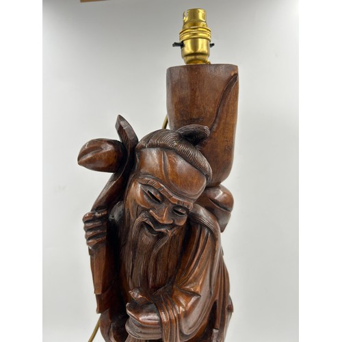 237 - A Chinese carved hardwood figure of a gentleman made into a table lamp. Height 68cm.