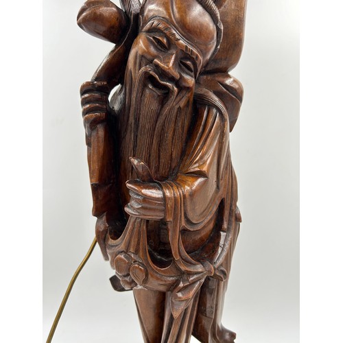 237 - A Chinese carved hardwood figure of a gentleman made into a table lamp. Height 68cm.