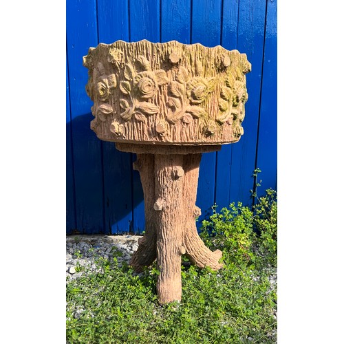 239 - A pair of reconstituted stone faux wood planters with floral decoration. Height 70cm. Diameter 45cm.