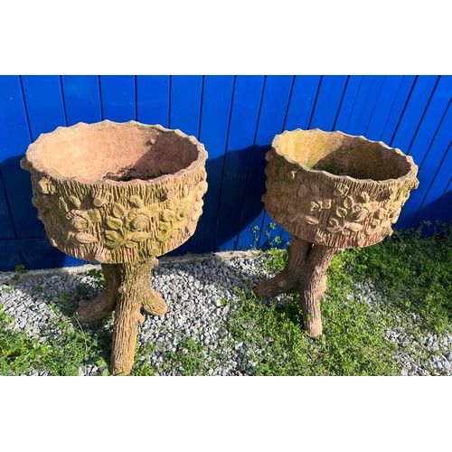 239 - A pair of reconstituted stone faux wood planters with floral decoration. Height 70cm. Diameter 45cm.