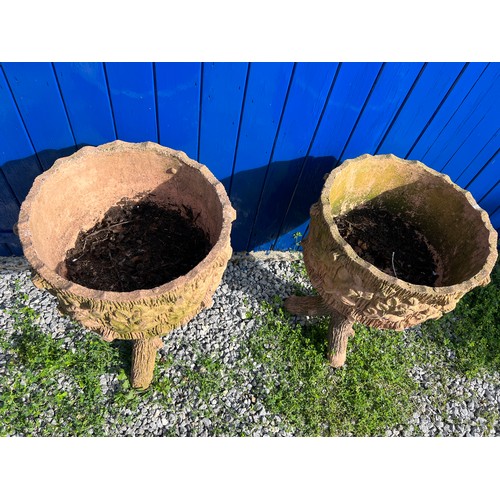 239 - A pair of reconstituted stone faux wood planters with floral decoration. Height 70cm. Diameter 45cm.