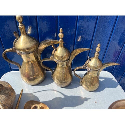 933 - Brassware to include three matching middle eastern early brass dallah coffee pots of different sizes... 