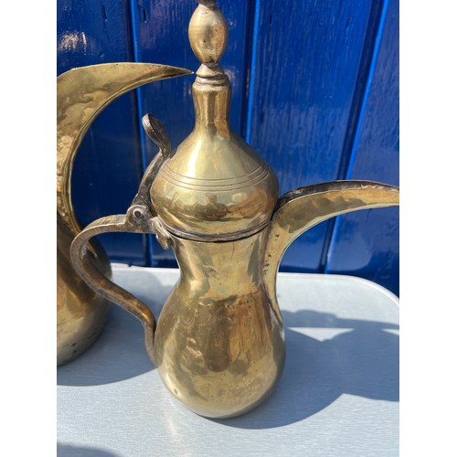 933 - Brassware to include three matching middle eastern early brass dallah coffee pots of different sizes... 