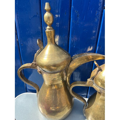 933 - Brassware to include three matching middle eastern early brass dallah coffee pots of different sizes... 