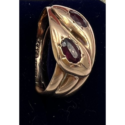 593 - A nine carat gold snake ring with garnet eyes. Weight 5.2gm. Size U.