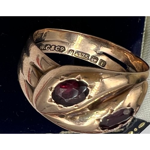 593 - A nine carat gold snake ring with garnet eyes. Weight 5.2gm. Size U.