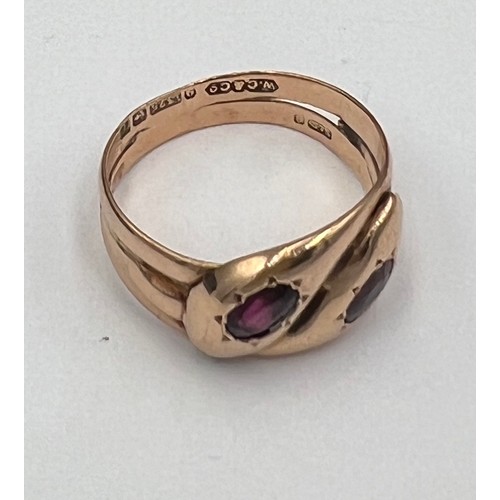 593 - A nine carat gold snake ring with garnet eyes. Weight 5.2gm. Size U.