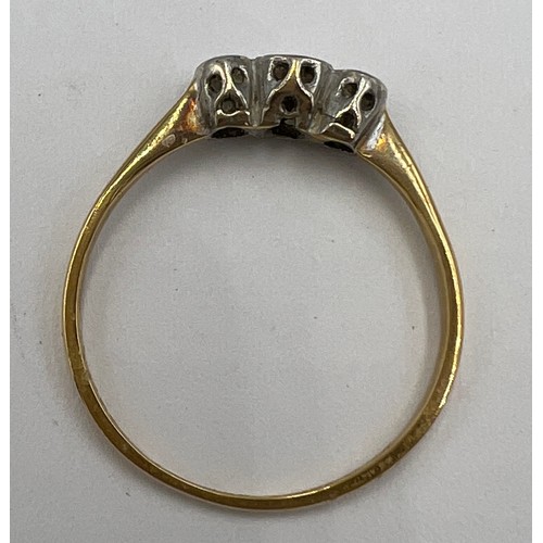 595 - A unmarked yellow and white metal ring set with three diamonds. Size R. Weight 1.9gm.