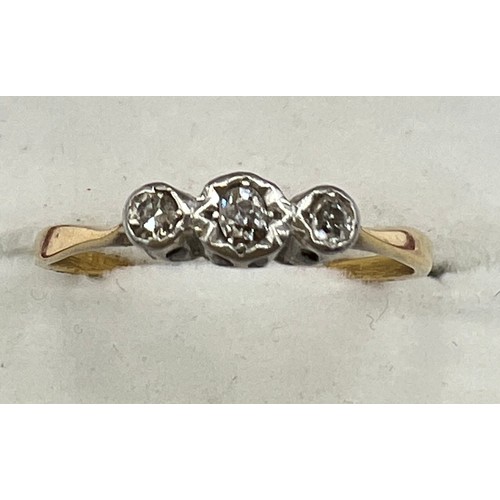 595 - A unmarked yellow and white metal ring set with three diamonds. Size R. Weight 1.9gm.