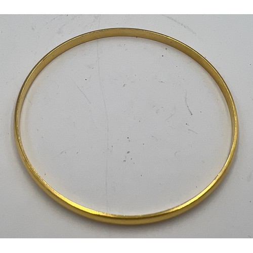 600C - A yellow metal bangle, tests as approximately 18 carat gold. Weight 8.2gm. 7cm diameter.