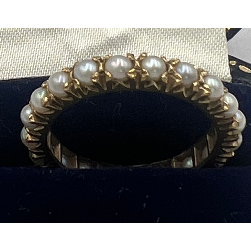 621A - A yellow metal ring (tests as 9 carat gold) set with whole cultured pearls. Size R, weight 3.3gm.