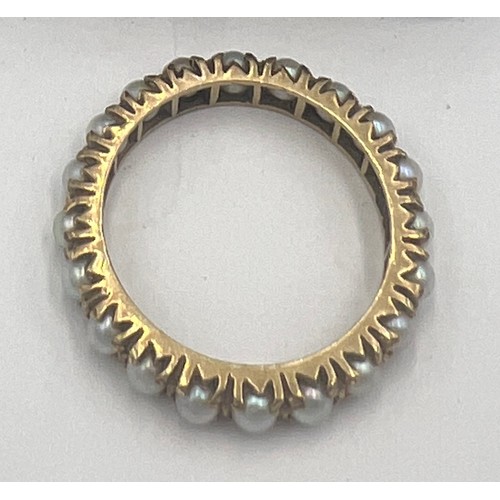 621A - A yellow metal ring (tests as 9 carat gold) set with whole cultured pearls. Size R, weight 3.3gm.