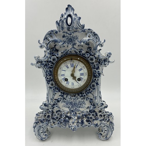 998A - A 19thC blue and white porcelain Continental clock garniture, comprising clock 38.5cm with two vases... 