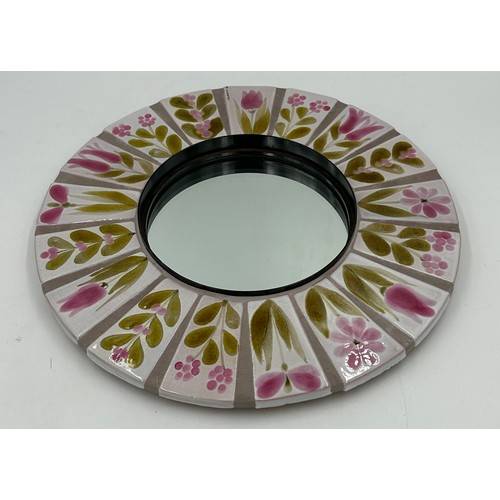 1150 - A vintage ceramic and metal mirror with floral tile decoration by Roger Capron. 39cm d.