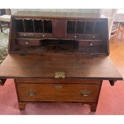 33 - An early 19thC oak bureau with brass handles and bracket feet. 94cm w x 107cm h x 49cm d.