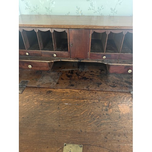 33 - An early 19thC oak bureau with brass handles and bracket feet. 94cm w x 107cm h x 49cm d.