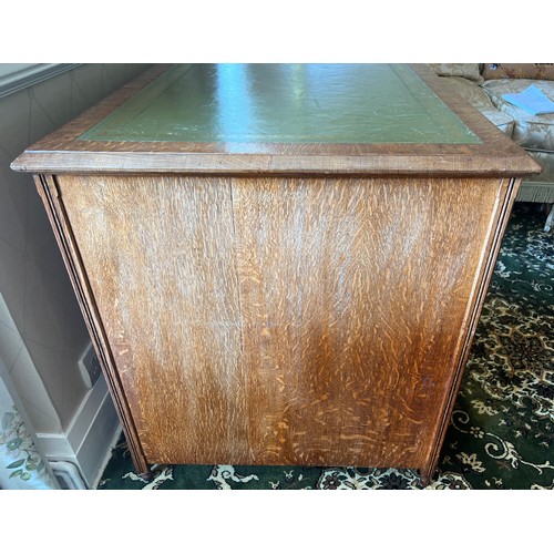 34 - A 19thC oak desk with tooled green leather top and brass drop handles. 115cm w x 68cm d x 76cm h.