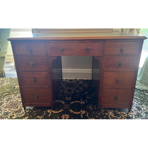 34 - A 19thC oak desk with tooled green leather top and brass drop handles. 115cm w x 68cm d x 76cm h.