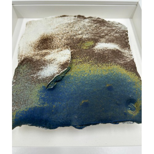 430 - A Pair of Contemporary Ceramic artworks in white box frames depicting landscapes/sea/mountains 25.5c... 