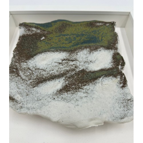 430 - A Pair of Contemporary Ceramic artworks in white box frames depicting landscapes/sea/mountains 25.5c... 