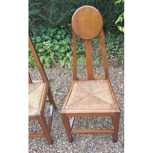 23 - A pair of Arts & Crafts rush seated oak chairs. 98cm h x 41cm w x 38cm d. Height to seat 42cm.