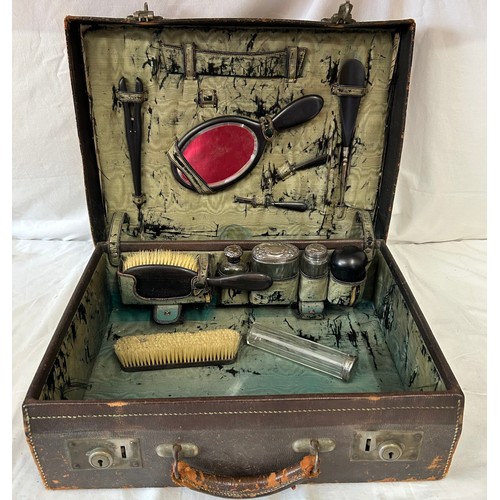 947 - An Edwardian leather Vanity Case comprising of ebony brushes, tweezers, comb, mirror, shoe horn, pow... 