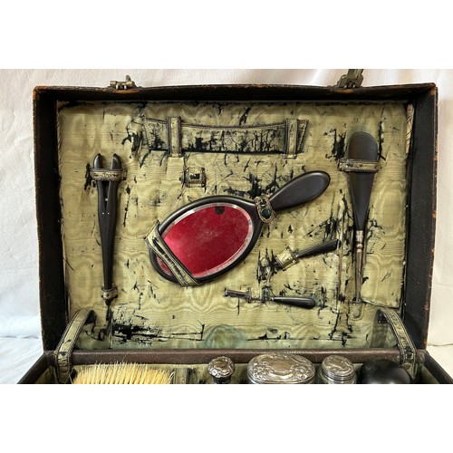 947 - An Edwardian leather Vanity Case comprising of ebony brushes, tweezers, comb, mirror, shoe horn, pow... 