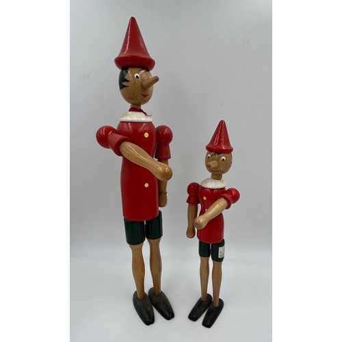 464 - Four Italian wooden Pinocchio figures 2 of which are money boxes with keys. Tallest 51cm.