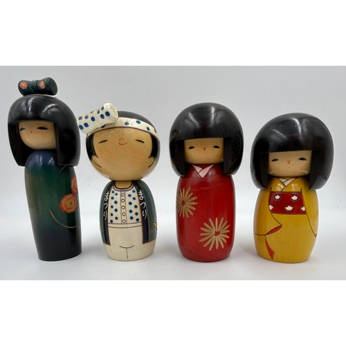 1009 - A collection of traditional wooden hand painted Japanese Kokeshi dolls one which is a keyring larges... 