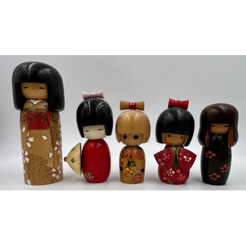 1009 - A collection of traditional wooden hand painted Japanese Kokeshi dolls one which is a keyring larges... 