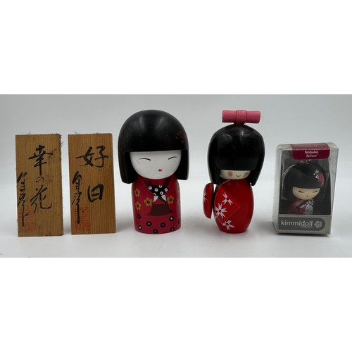 1009 - A collection of traditional wooden hand painted Japanese Kokeshi dolls one which is a keyring larges... 