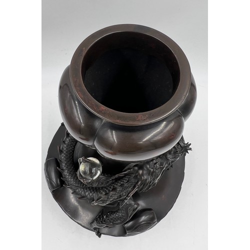 1011 - A Japanese bronze dragon vase, the dragon clutching rock crystal tama. 33cm h.