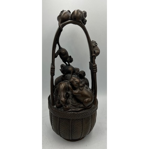 1014 - Japanese bronze rats in a basket. 24cm h.