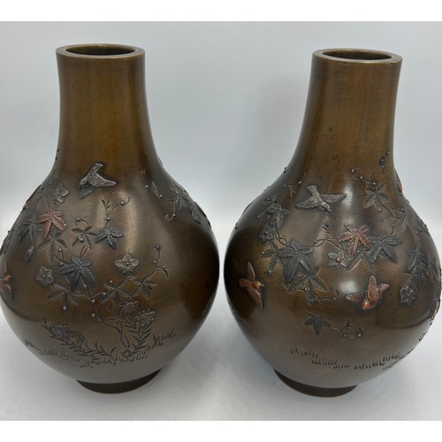 1020 - A pair of Japanese Meiji period carved and inlaid bronze vases. 17cm h. Signature to both bases.