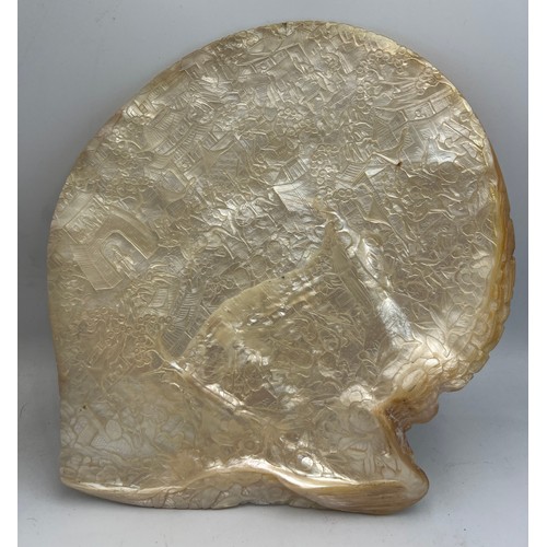 1034 - A Chinese profusely carved mother of pearl shell. 21cm x 20cm, diagonal 23cm.