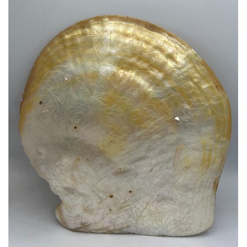 1034 - A Chinese profusely carved mother of pearl shell. 21cm x 20cm, diagonal 23cm.