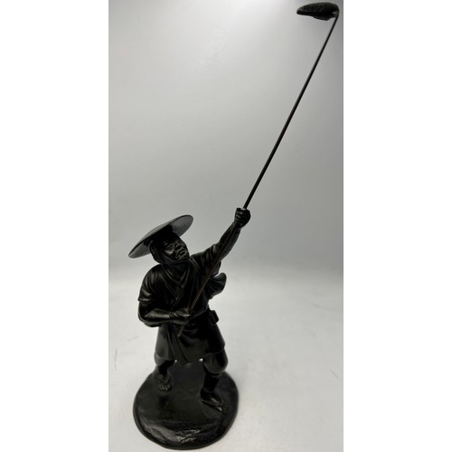 1043 - A Japanese bronze figure of a fisherman 30cm h together with two carved black stone figures of gentl... 