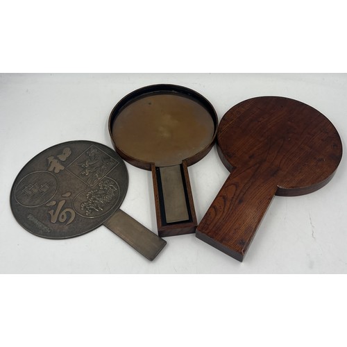 1044 - Two Japanese bronze hand mirrors in a lacquered case. 32cm x 20cm.