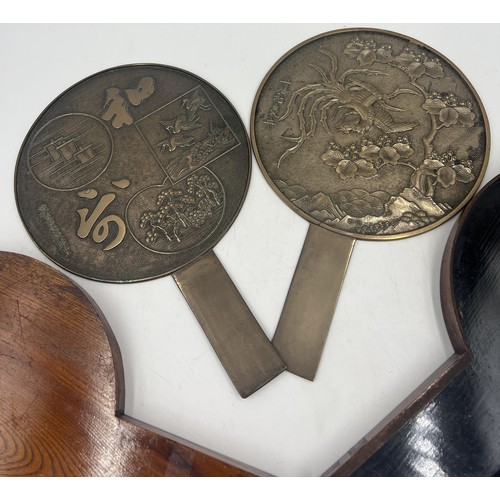 1044 - Two Japanese bronze hand mirrors in a lacquered case. 32cm x 20cm.