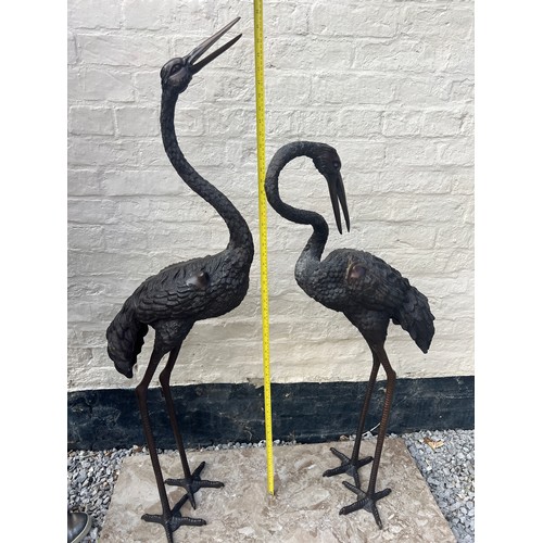 1052 - A pair of Japanese bronze cranes on later marble base. Height 132cm.