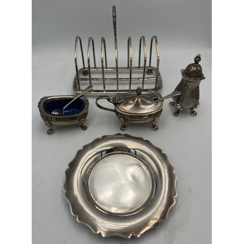 855 - Hallmarked silver to include Victorian toast rack, Birmingham 1886, three piece cruet set with two s... 