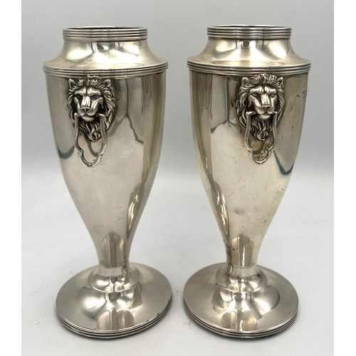 862 - A pair of silver vases with lion mask drop handles and weighted bases. 15cm h. Weight 700gm. London ... 