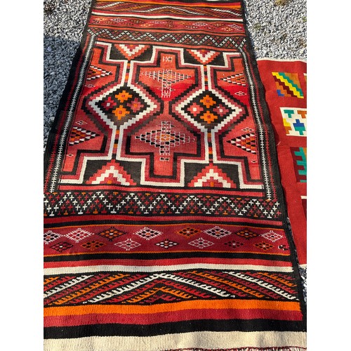 1287 - A multicoloured Kilim rug 143 x 79cm together with a red, orange and black wool rug 258 x 126cm.