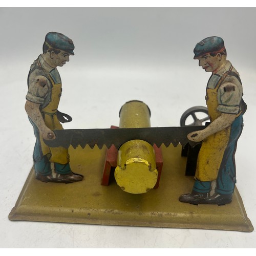 1292 - A vintage toy with men sawing a log. 14cm x 7.5cm.