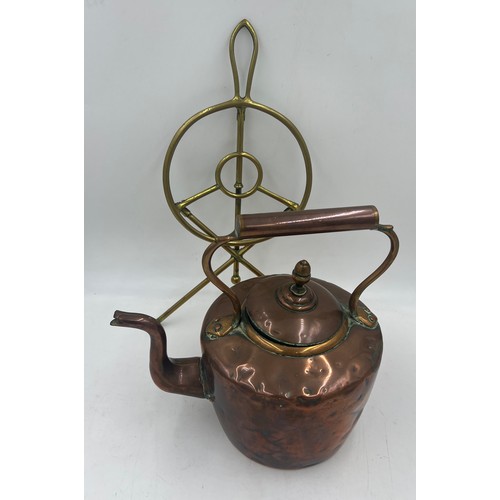 1070 - A 19thC folding brass trivet together with a 19thC copper kettle. 31cm h.