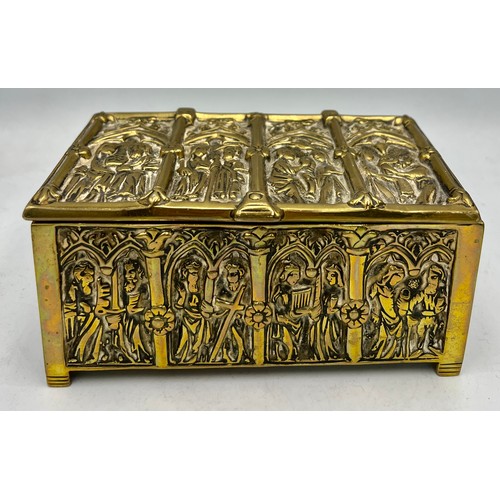 1071 - A brass wood lined casket depicting religious scenes. 15cm x 9 cm x 7cm h together with a tiny Buddh... 