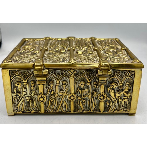 1071 - A brass wood lined casket depicting religious scenes. 15cm x 9 cm x 7cm h together with a tiny Buddh... 