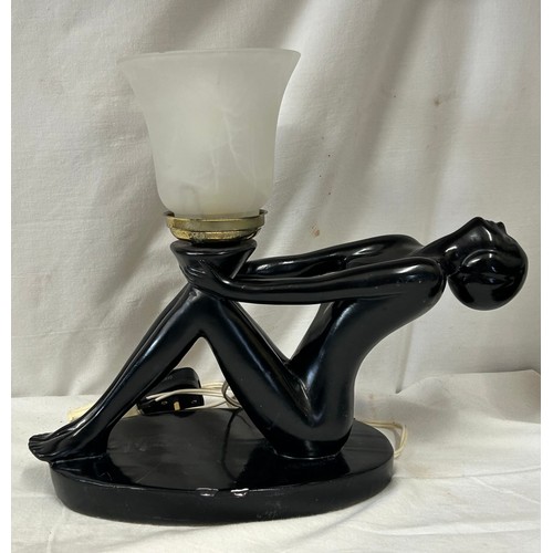 1129 - A pair of art deco style ebonised plaster table lamps, of female form holding opaque marbled glass s... 