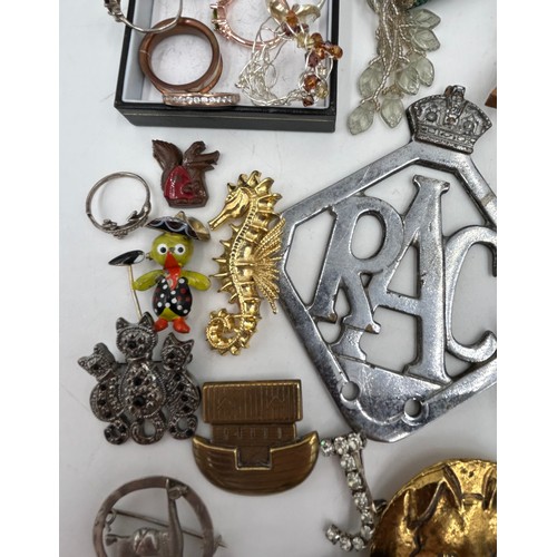 1374 - A quantity of costume jewellery to include silver rings, various brooches, a RAC car badge.