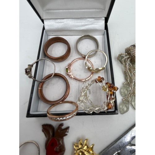 1374 - A quantity of costume jewellery to include silver rings, various brooches, a RAC car badge.